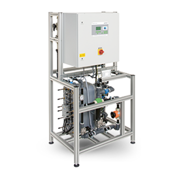 Eine technische Anlage mit Schaltschrank steht auf einem Metallrahmen mit sichtbaren Rohren und Ventilen.