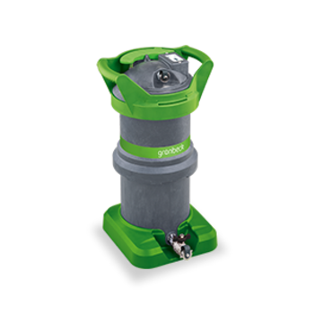 Eine grau-grüne Mischbettpatrone mit Griffen und der Aufschrift "grünbeck" steht auf einem quadratischen grünen Sockel.