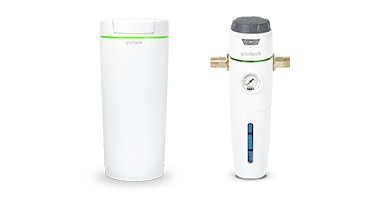 Links eine Enthärtungsanlage und rechts ein Wasserfilter mit Manometer und Anschlüssen, beide stehen nebeneinander vor einem weißen Hintergrund.